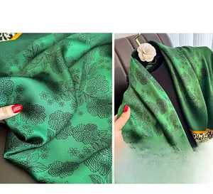 Detail of silk-satin scarf featuring vibrant green floral prints and leopard borders