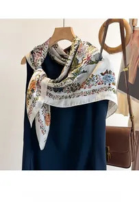 Dettaglio di un elegante foulard in raso con motivi floreali abbinato a un abito blu