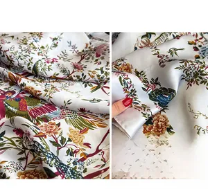 Dettaglio di un foulard in seta sintetica con motivi floreali e uccelli vivaci