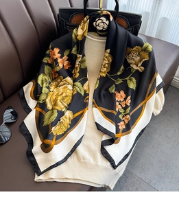 Detail of silk scarf featuring large yellow roses on black with white contrast border