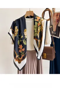 Detail of vintage floral pattern on a navy blue silk scarf styled with a brown leather bag