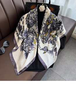Detail of floral butterfly print silk scarf on a handbag for travel and beach outings