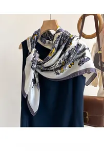 Detailed view of silk scarf with purple butterfly print tied on a black dress