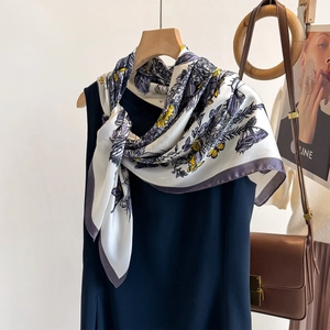 Elegant butterfly print silk scarf in cream and yellow tied to a navy dress