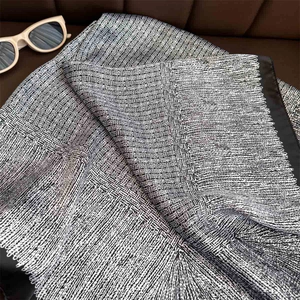 Houndstooth and striped silk scarf with sunglasses on a leather background