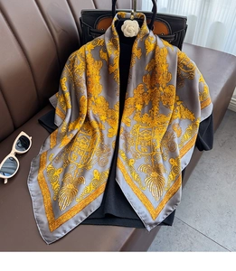 Detail of grey silk satin scarf featuring gold baroque patterns and royal crest design