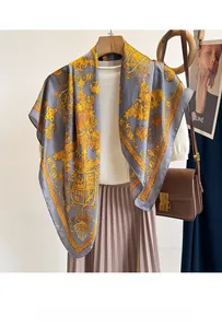 Detail of silk-like square scarf featuring golden baroque patterns and vintage crests