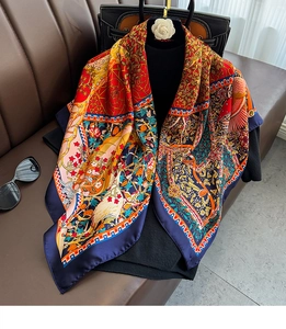 Detail view of retro floral and bird print silk scarf with rich navy and orange tones