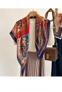 Detail of silk-feel scarf featuring vintage floral and bird prints in red and blue