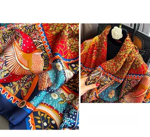 Detail of silk satin scarf featuring ethnic bird and flower patterns on a black handbag