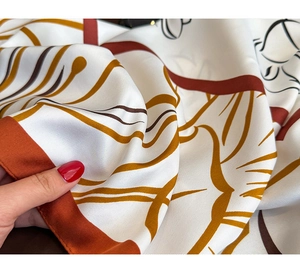 Close-up of printed silk scarf showing smooth texture and geometric floral pattern