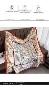 Detail of 90x90cm floral polyester silk scarf draped on a leather sofa with fashion props