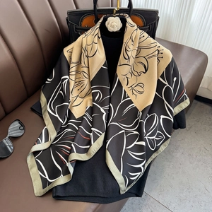 Floral print silk scarf with black and khaki patterns, styled with elegant accessories