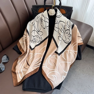 Detail of silk satin scarf with floral patterns styled with a camellia decorative buckle