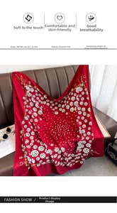 Detailed view of red twill silk scarf with white roses and golden chain patterns