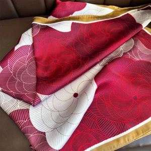 Close-up of elegant floral pattern on large square silk scarf with rolled edges