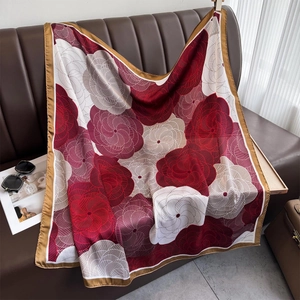 Floral printed silk scarf with red and grey spiral patterns on brown leather sofa
