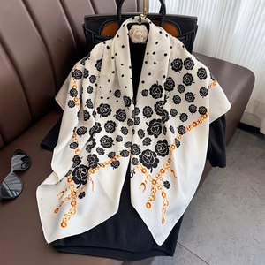 90cm silk twill scarf with black camellia rose and gold chain patterns on a handbag