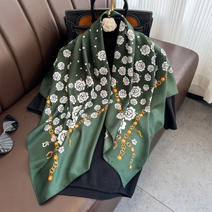 Detail of dark green silk scarf with white camellia flowers and gold chain prints