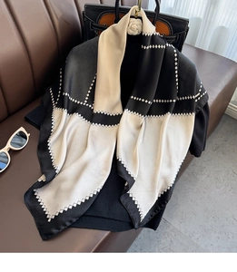 Detail of silk-satin square scarf with black and white geometric diamond pattern textures