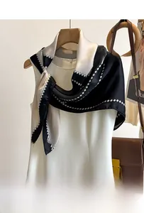 Detail of silk-feel scarf with geometric diamond pattern on white sleeveless dress