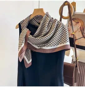 Gros plan détaillé d'un foulard en soie à motif pied-de-poule avec bordure marron