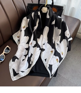 Détail d'un foulard élégant en satin noir et blanc avec un motif floral soyeux