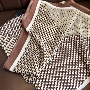Vue détaillée d'un foulard en soie de luxe à carreaux géométriques sur cuir marron