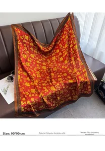 Detail of 90x90cm red silk-like scarf with yellow Fu character print on leather sofa