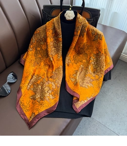 Détail d'un foulard carré en soie de 90 cm avec imprimé floral et bord bordeaux