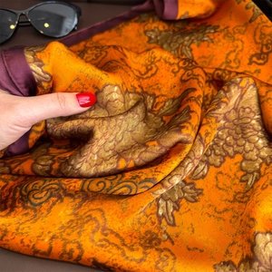 Détail d'un foulard carré en satin avec imprimés floraux vintage et texture soyeuse