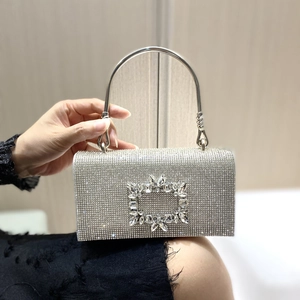 Detailed close-up of a silver rhinestone clutch bag featuring a large crystal rectangle buckle