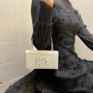 Close-up of sparkling silver evening clutch bag with crystal buckle and metal handle