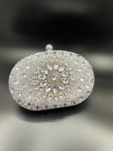 Detailed view of silver shell-shaped clutch bag with sunburst rhinestone patterns