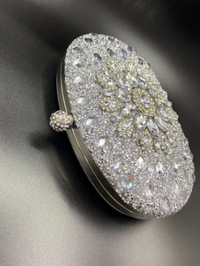 Macro view of shell evening bag with silver crystals and marquise rhinestone floral pattern