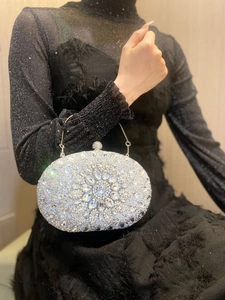 Detail of silver shell-shaped evening clutch with crystal rhinestones and floral pattern