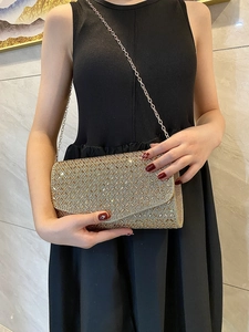 Close-up of gold sparkling rhinestone clutch with elegant cross-grid sequin texture