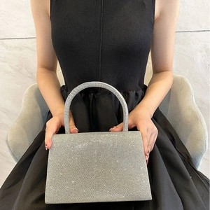 Elegant silver glitter evening handbag with trapezoid shape and metallic top handle