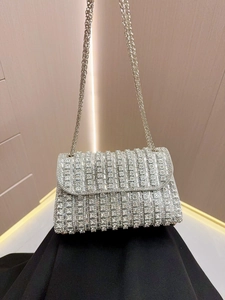 Detail of silver rhinestone evening bag featuring hand-set crystals and metal chain strap