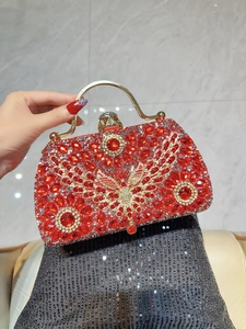 Detail of red rhinestone evening bag with gold butterfly accent and metal top handle