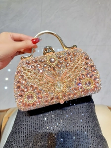 Detail of luxury rhinestone evening clutch with peach crystals and butterfly clasp