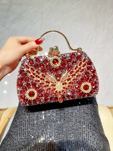 Macro detail of red crystal handbag with golden metal butterfly and luxury handle