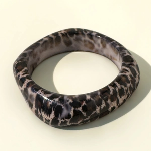 Detail of chunky leopard print resin bangle showing thick square frame and glossy finish