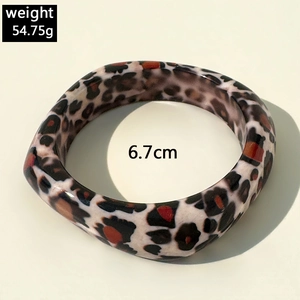 Detail view of leopard print resin bangle showing 54.75g weight and 6.7cm inner diameter