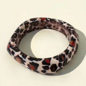 Detail view of thick square resin bangle featuring classic leopard print pattern