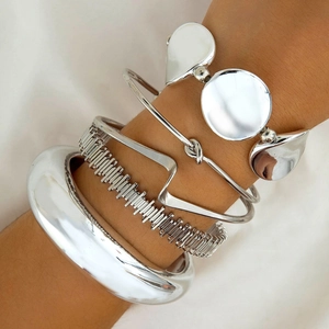 Five-piece stackable silver metal cuff bracelet set with geometric knots and wave textures