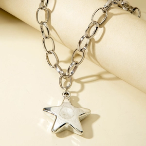 Detail of silver link chain necklace featuring a polished mirror star pendant on a stand
