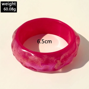 Detail view of pink resin bangle with glitter texture showing weight and 6.5cm diameter