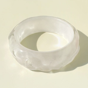 Detail of white irregular wave-patterned resin bangle with iridescent shimmering finish