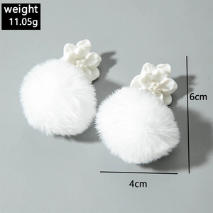 Detail showing white floral faux fur ball earrings with 6cm length and 11.05g weight